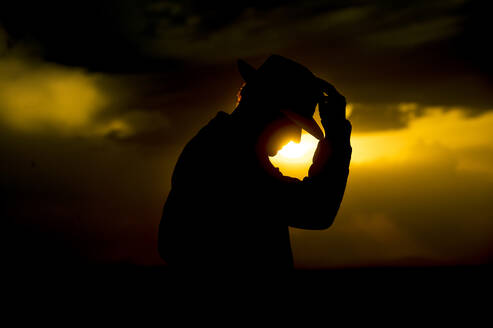 Silhouette älterer Mann mit Hut bei Sonnenuntergang - OCMF01601