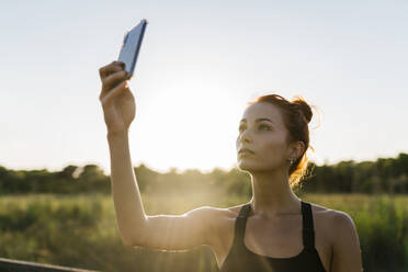 Young woman using phone against clear sky - EGAF00614