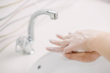 Woman washes her hands by surgical hand washing method. - CAVF87898