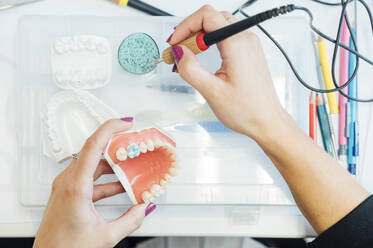 Von oben: Studentin mit künstlichem Zahnmodell und Bohrer-Lerntraining für zahnärztliche Behandlungen während des Unterrichts im Labor - ADSF08770