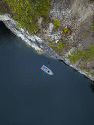 Russland, Republik Karelien, Ruskeala, Luftaufnahme eines Bootes am Ufer des Marmorsees - KNTF05063