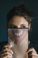 Young Woman Smiling Behind a Magnifying Glass - ALBF01342