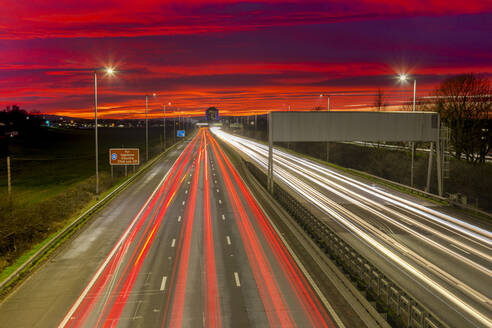 Roter Himmel Sonnenuntergang, Ampelspuren, Autobahn M8, Schottland, Vereinigtes Königreich, Europa - RHPLF17295