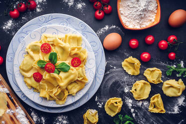 Italienische Pasta mit Zutaten und schwarzem Hintergrund. Gastronomisches Konzept - CAVF87943