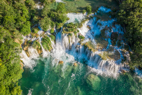 Luftaufnahme des von Bäumen umgebenen Wasserfalls Skradinski Buk mit türkisfarbenem Wasser in Lozovac, Kroatien - AAEF09235