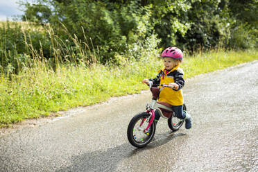 Kleinkind-Mädchen mit rosa Fahrradhelm auf Balance-Fahrrad - BRF01485
