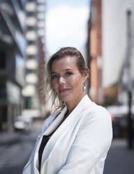 Portrait of confident businesswoman in business district in the city - HPSF00047