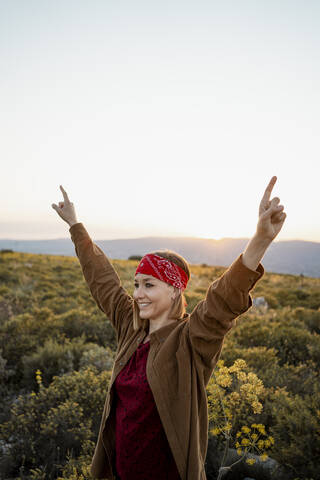 Happy woman with raised arms in the countryside stock photo