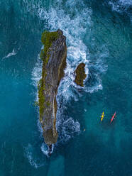 Indonesien, Bali, Luftaufnahme von Kajakfahrern beim Passieren von Stapelfelsen in der Nähe des Ufers der Insel Nusa Penida - KNTF05110