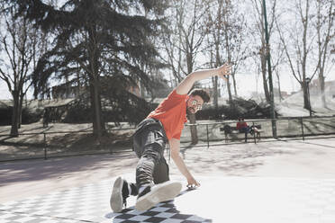 Young athletic guy practicing break dance in park in sunny weather - ADSF08948