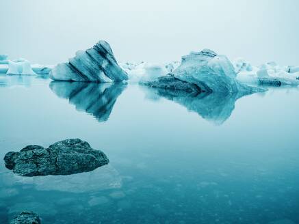 Malerische Ansicht von Eis auf der Wasseroberfläche zwischen Schnee im Winter in Island - ADSF08969