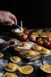 Hausgemachte Ravioli mit Parmesan, Tomaten und Basilikum, ein typisches Gericht der italienischen Küche - ADSF09024