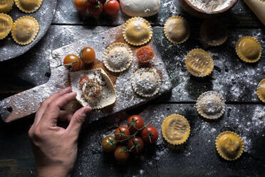 Hausgemachte Ravioli mit Parmesan, Tomaten und Basilikum, ein typisches Gericht der italienischen Küche - ADSF09031