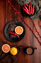 Becher mit leckerer heißer Schokolade auf einem Holztisch neben verschiedenen Desserts und Früchten zum Frühstück - ADSF09043
