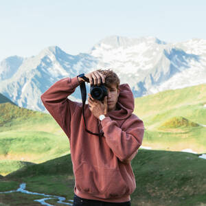 Mann fotografiert in Berglandschaft - ADSF09144