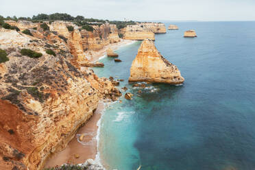 Sauberes blaues Meer, das an einem wolkenlosen Tag in Portugal an rauen Felsenklippen vorbeizieht - ADSF09147