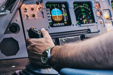 Anonymer männlicher Pilot bei der manuellen Steuerung eines modernen Flugzeugs während des Flugs - ADSF09170