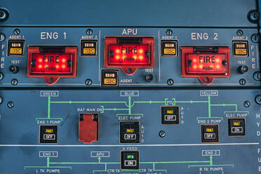 Closeup of fire buttons and warning lights on control console in cockpit of contemporary airplane - ADSF09172