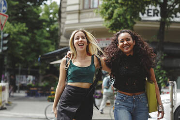 Junge schöne fröhliche Frauen gehen auf Berliner Straße am Sommertag - ADSF09183