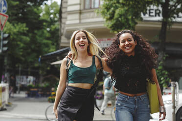 Young beautiful cheerful women walking on Berlin street on summer day - ADSF09183