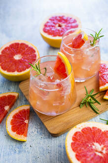 Gläser mit frischem Grapefruitsaft und Grapefruits - GIOF08614