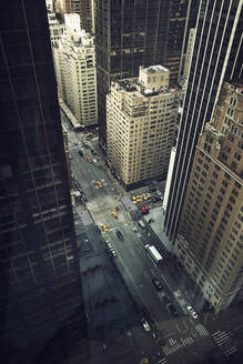 Von oben auf eine Straße mit Fahrzeugen, die zwischen Hochhäusern im Zentrum von New York fahren - ADSF09209