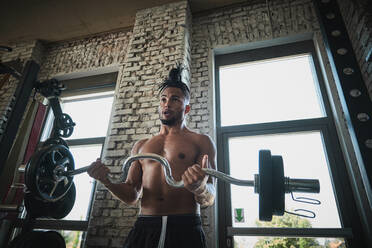 Black man exercising with barbell in gym - ADSF09214