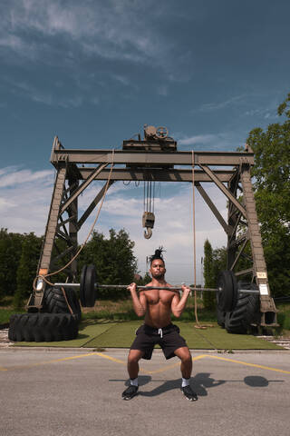 Black guy with barbell in outdoor gym stock photo