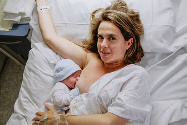 Mother breastfeeding her newborn son in hospital - ADSF09254
