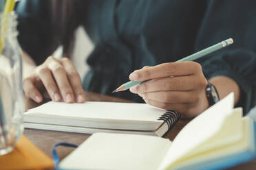 Close up hands with pen writing on notebook. - CAVF88008