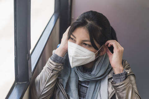 Frau mit Maske im Bus während des Ausbruchs des Coronavirus, lizenzfreies Stockfoto