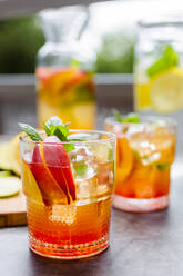 Cocktail with peach, mint and lime and ice cubes - GIOF08709
