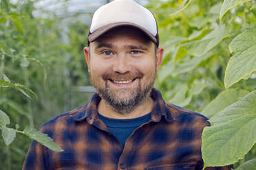 Portrait of smiling farmer in a greenhouse - KNTF05157