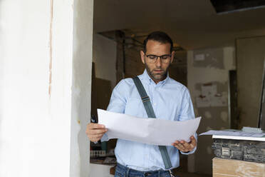 Architekt studiert Plan in einem im Bau befindlichen Haus - VABF03287