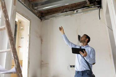 Architekt mit Tablet in einem im Bau befindlichen Haus - VABF03300