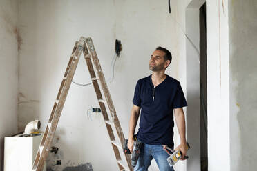 Confident construction worker standing in a house under construction - VABF03322