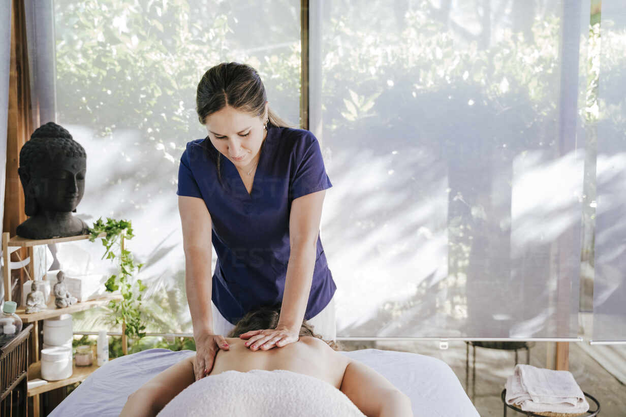 woman giving back massage to a girl Stock Photo