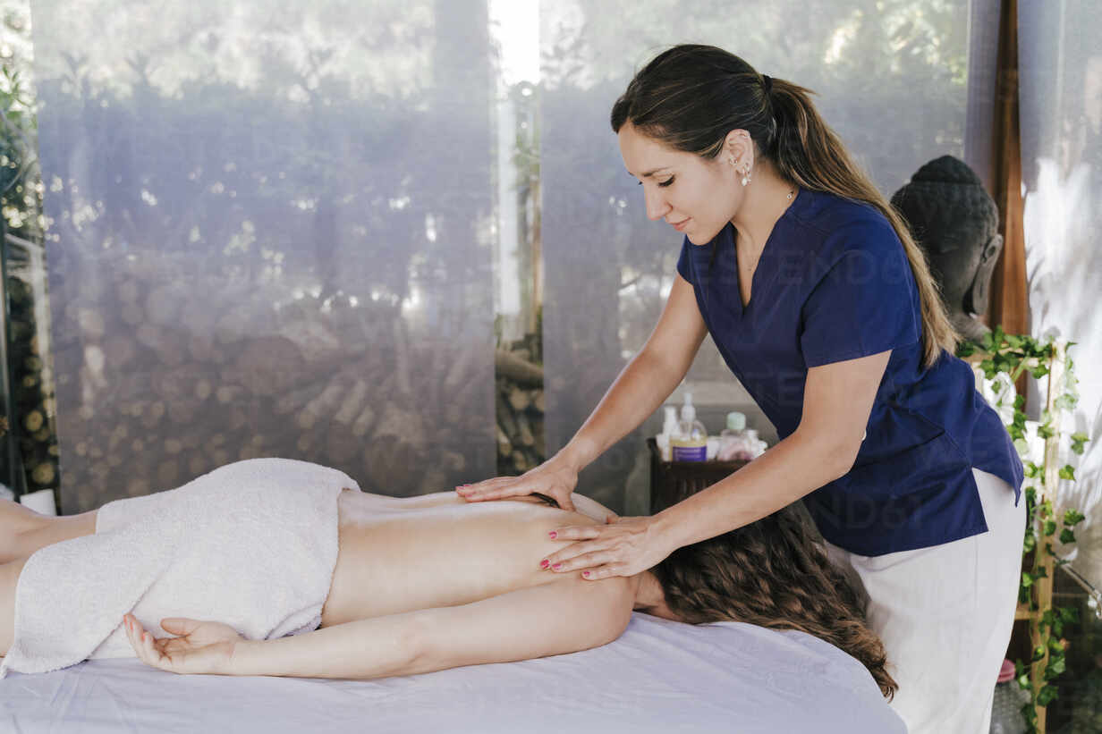 woman giving back massage to a girl Stock Photo