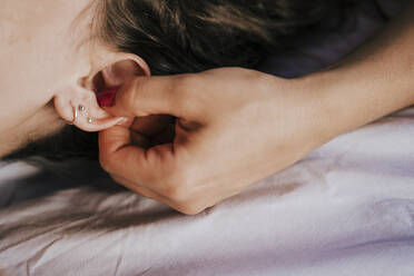 Close-up of female therapist giving ear massage to woman in health spa - EBBF00536