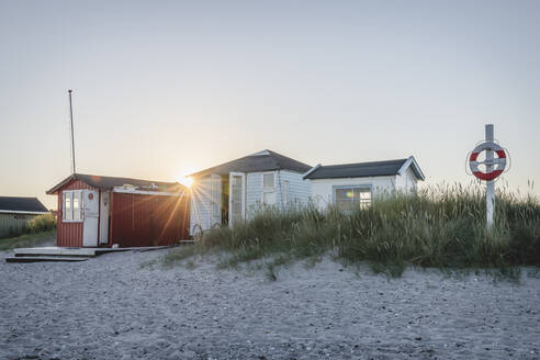 Dänemark, Region Süddänemark, Marstal, Rettungsring, der bei Sonnenuntergang vor einem Badehaus am Strand hängt - KEBF01571