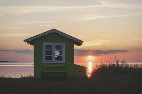 Denmark, Region of Southern Denmark, Aeroskobing, Small coastal bathhouse at sunset - KEBF01584