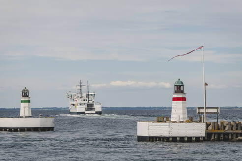 Dänemark, Region Süddänemark, Soby, Zwei Leuchttürme an der Küste mit einem wegfahrenden Schiff im Hintergrund - KEBF01591