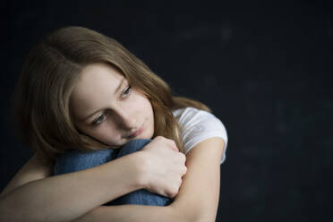 Portrait of blond girl in front of black wall - DKOF00013