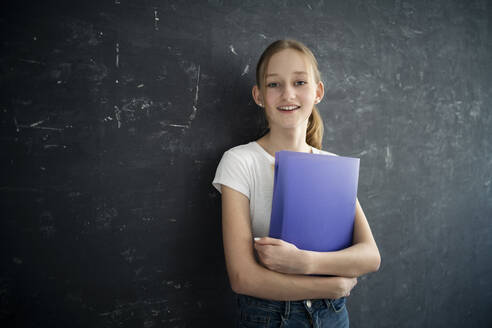 Girl with exersice books in front of black wall - DKOF00024