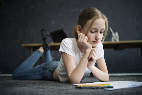 Girl lying on carpet and learning at home - DKOF00028