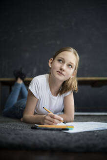 Girl lying on carpet and learning at home - DKOF00030