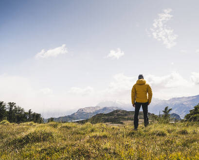 Mann betrachtet die Aussicht, während er auf einem Berg in Patagonien, Argentinien, Südamerika steht - UUF20808