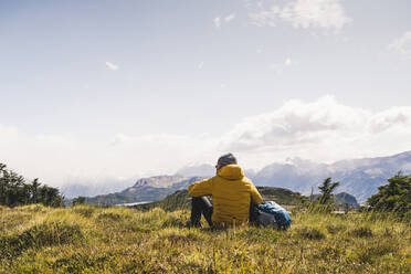 Man looking at view while sitting on mountain at Patagonia, Argentina, South America - UUF20811