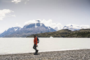 Mann beim Spaziergang am Seeufer im Torres Del Paine Nationalpark, Chile, Patagonien, Südamerika - UUF20820