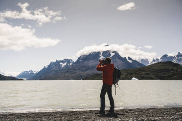 Mann mit Fernglas beim Wandern im Torres Del Paine National Park, Patagonien, Chile, Südamerika - UUF20822